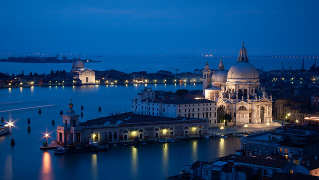 Venice basilica at night. Santa Maria della Salute church illuminated along Grand Canal dusk skyline.