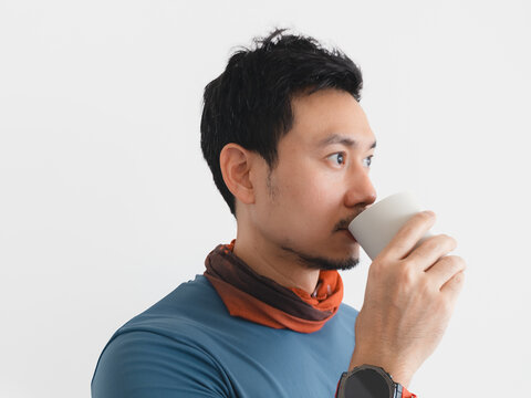 Asian Man Drinking from a White Cup in Profile