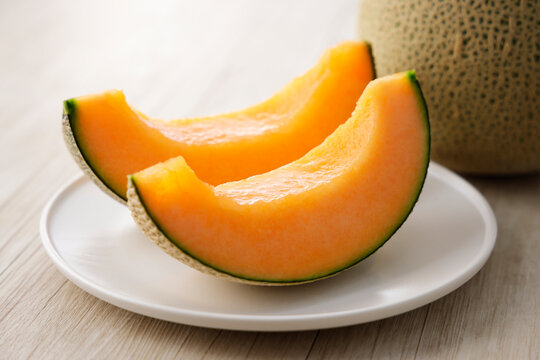 テーブルに置かれた北海道産の赤肉カットメロン　Cut orange flesh Japanese melon on a table, Hokkaido cantaloupe