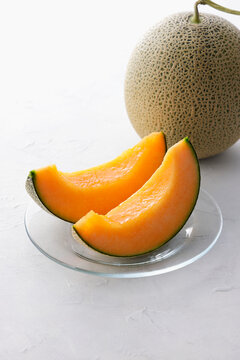 テーブルに置かれた北海道産の赤肉カットメロン　Cut orange flesh Japanese melon on a table, Hokkaido cantaloupe
