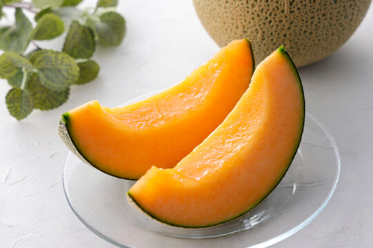テーブルに置かれた北海道産の赤肉カットメロン　Cut orange flesh Japanese melon on a table, Hokkaido cantaloupe