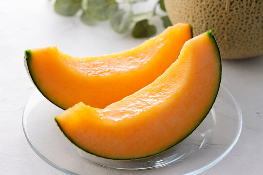 テーブルに置かれた北海道産の赤肉カットメロン　Cut orange flesh Japanese melon on a table, Hokkaido cantaloupe