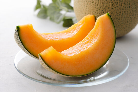 テーブルに置かれた北海道産の赤肉カットメロン　Cut orange flesh Japanese melon on a table, Hokkaido cantaloupe