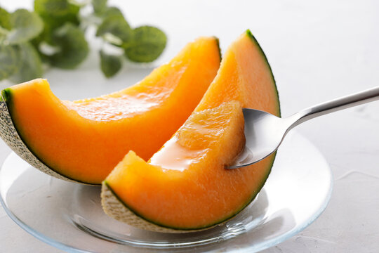 テーブルに置かれた北海道産の赤肉カットメロン　Cut orange flesh Japanese melon on a table, Hokkaido cantaloupe