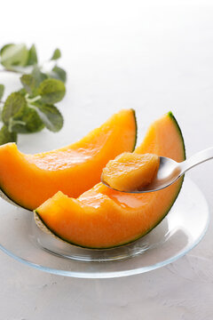 テーブルに置かれた北海道産の赤肉カットメロン　Cut orange flesh Japanese melon on a table, Hokkaido cantaloupe