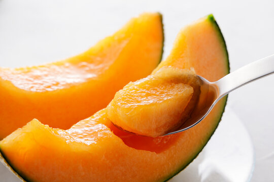 テーブルに置かれた北海道産の赤肉カットメロン　Cut orange flesh Japanese melon on a table, Hokkaido cantaloupe