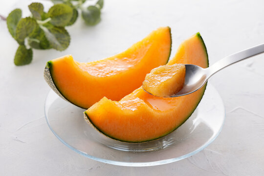 テーブルに置かれた北海道産の赤肉カットメロン　Cut orange flesh Japanese melon on a table, Hokkaido cantaloupe