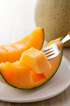 テーブルに置かれた北海道産の赤肉カットメロン　Cut orange flesh Japanese melon on a table, Hokkaido cantaloupe