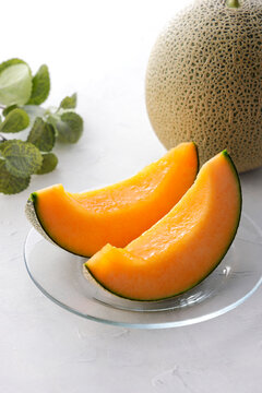 テーブルに置かれた北海道産の赤肉カットメロン　Cut orange flesh Japanese melon on a table, Hokkaido cantaloupe
