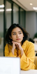 Obraz premium Thoughtful young woman in yellow shirt portrait for office background and corporate headshot banner design for professional websites and profile