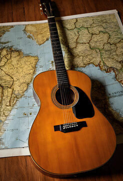 Acoustic guitar resting on a vintage world map travel adventure music and global exploration on a wooden floor, instrument