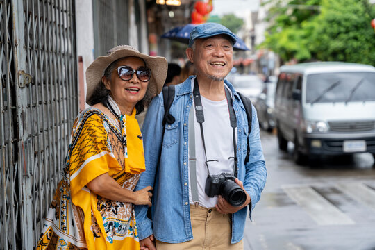 Happy Senior Asian Couple Sightseeing and Exploring Old Town Street