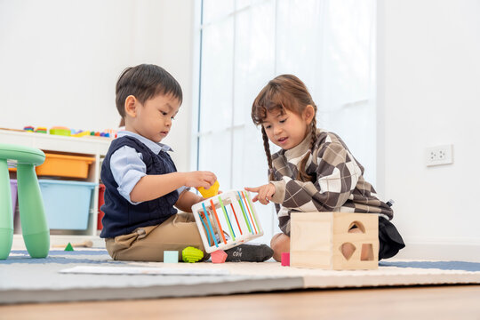 Asian Children Playing Educational Toys Together in Playroom