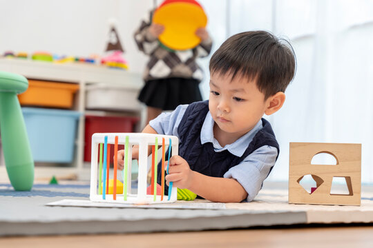 Asian Little Boy Playing Educational Shape Toy on Floor
