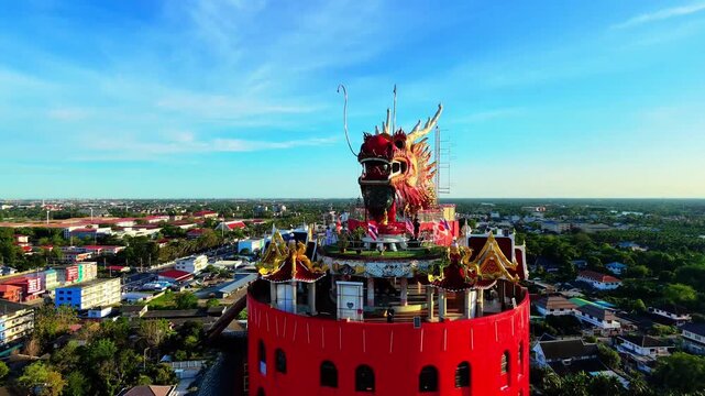 Aerial view ascending and pulling back from giant dragon head at Wat Samphran Dragon Temple, Nakhon Pathom, Thailand