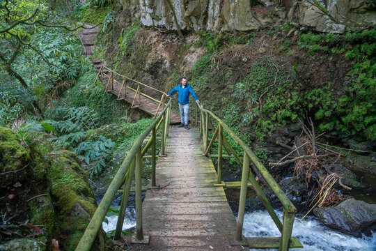 A white European man in a blue coat on a pedestrian bridge on S&atilde;o Miguel Island. A white European man in a blue coat on a pedestrian bridge on S&atilde;o Miguel Island, Azores, Portugal.