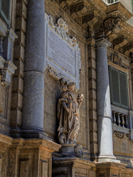 A detailed architectural view of a Baroque marble statue symbolizing the seasons at the historic Quattro Canti intersection in Palermo, Sicily, framed against weathered stone walls.