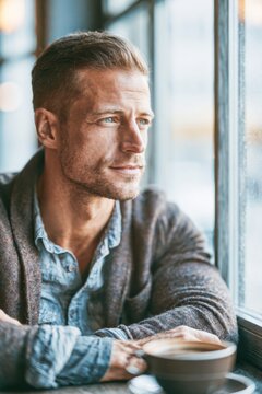 Young Adult Man Having Coffee in Bright Modern Cafe