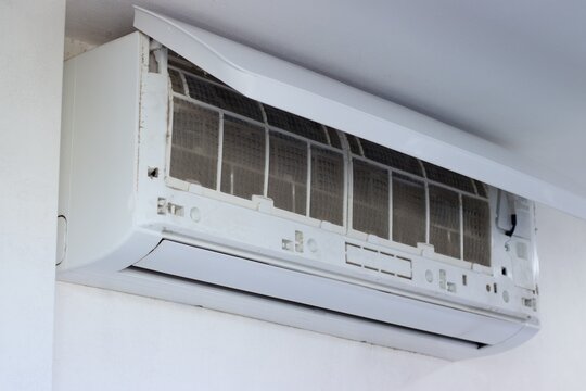 Close up of a wall mounted air conditioner with dusty filters exposed during maintenance Highlighting cleaning service indoor air quality and HVAC care