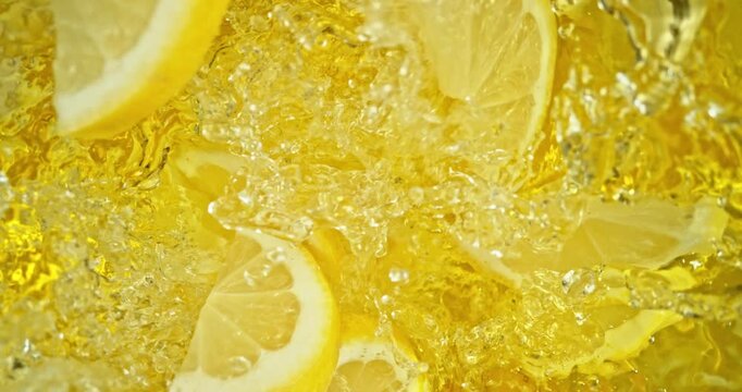 Super slow motion 1000fps video of fresh lemon slices falling into rippling water, creating a sparkling splash, perfect for drink, cocktail and summer visuals.
