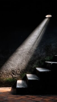 Concrete stairway with light and shadow creates a dramatic scene in an urban setting with strong chiaroscuro effects and a textured wall in focus