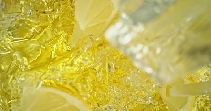 Super slow motion 1000fps video of fresh lemon slices falling into rippling water, creating a sparkling splash, perfect for drink, cocktail and summer visuals.
