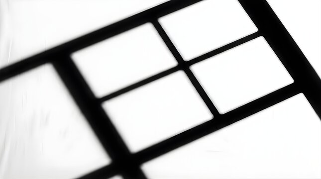 Abstract shadow of a window frame projected onto a white wall surface