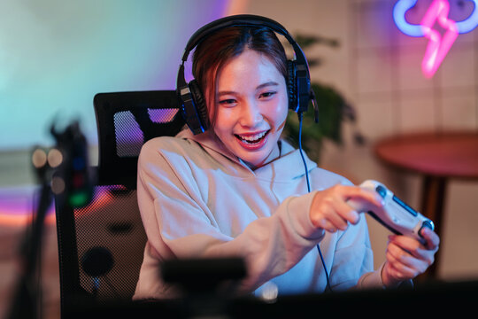 Excited young female gamer playing intense online video games we