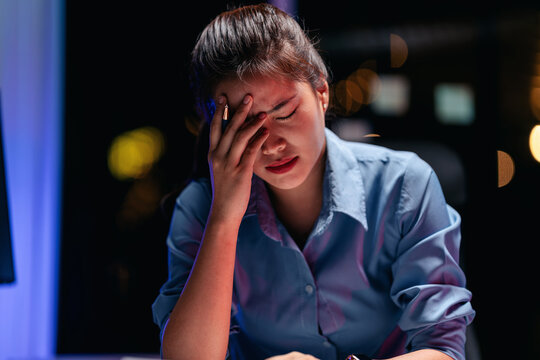 An adult woman experiencing profound stress and fatigue while wo