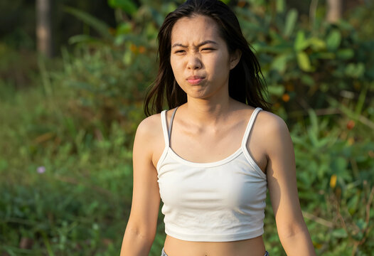 Young woman in white tank top outdoors at golden hour