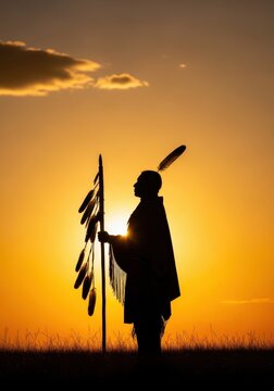 Majestic Silhouette of Native American Warrior with Feathered Staff Against Golden Sunset Sky