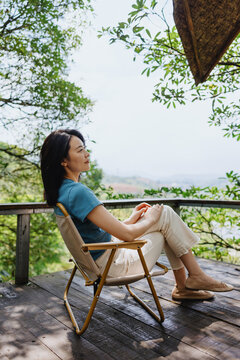 Woman Relaxing on Scenic Wooden Deck Overlooking Nature