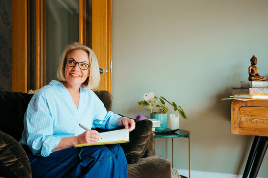 Portrait of middle aged woman writing in a notebook