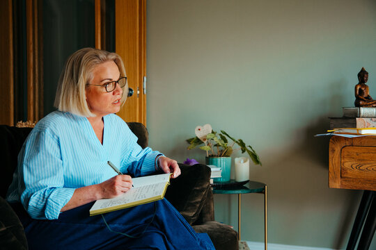 Portrait of middle aged woman writing in a notebook