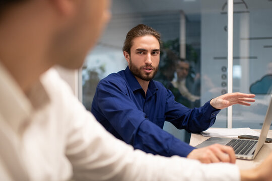 Bearded male manager talking with colleague during meeting