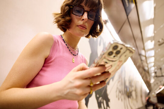Attractive woman checks her phone while in a subway 