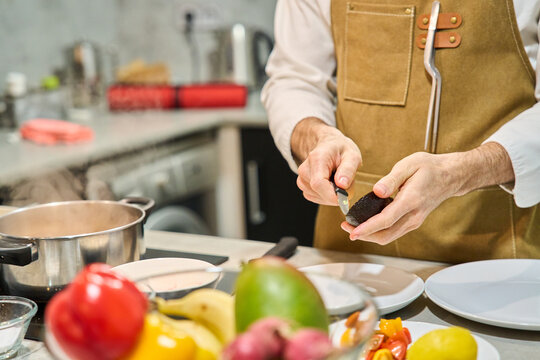 Chef hands preparing avocado for healthy meal