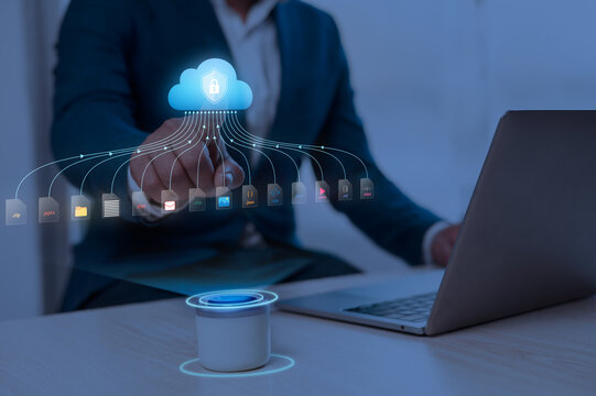 Business professional using cloud storage for secure data management. Executive accessing digital files with futuristic holographic interface on la...