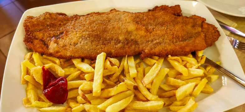 Traditional asturian cachopo with french fries and ketchup