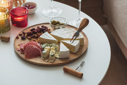 Cheese board platter with wine and lit candles