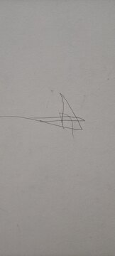 Close-up of a random black pen scribble or doodle on a plain off-white paper background.
