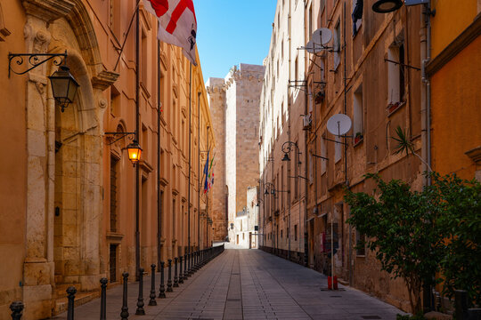 Narrow street in the historic Castello district of Cagliari with the Elephant Tower in the background, Sardinia, Italy