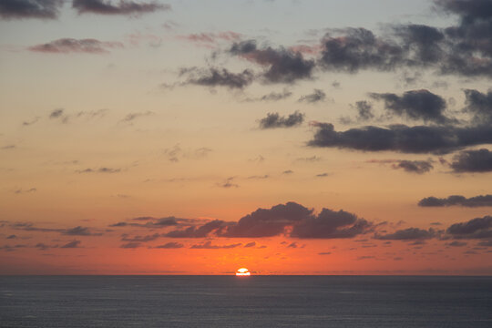 Sole al tramonto sull'oceano con nuvole
