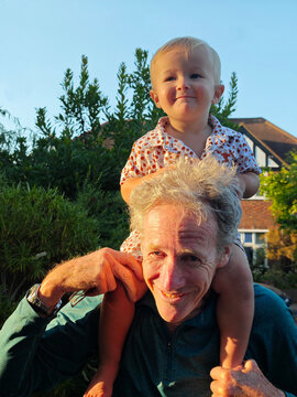 Smiling grandfather with grandson on shoulders