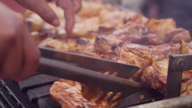 Extreme Close Up Macro of Hand Turning Perfectly Cooked Golden Barbecue Chicken on Grill