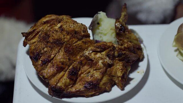 Close Up of Served Peruvian Pollada with Grilled Chicken Chorizo Sausage and Potatoes on Plate