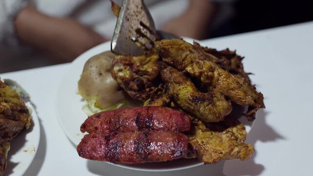 Close Up of Served Peruvian Pollada with Grilled Chicken Chorizo Sausage and Potatoes on Plate