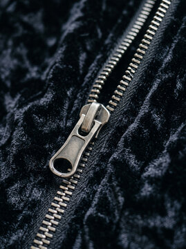 Metallic Zipper Slider Close Up on Dark Crushed Velvet Jacket Fabric