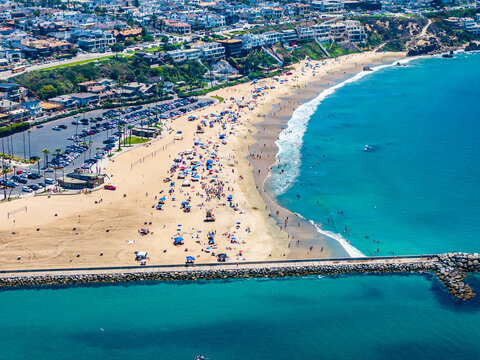 aerial landscape view of Corona del Mar State Beach, located in Corona del Mar, a seaside neighborhood in the city of Newport Beach, California with many people sunbathing at the beach and swimming