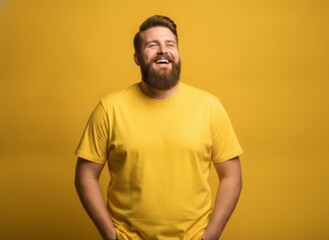 Obraz premium Happy man in yellow t-shirt smiling against a bright yellow background